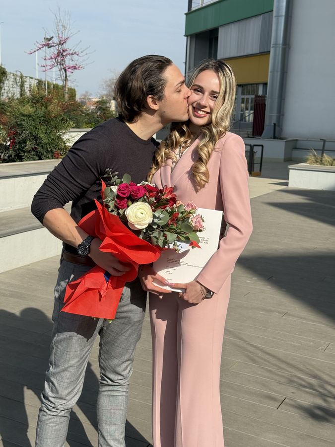 Fiori rossi, un bacio sulla guancia e un orgoglio che non stava in nessuna foto.